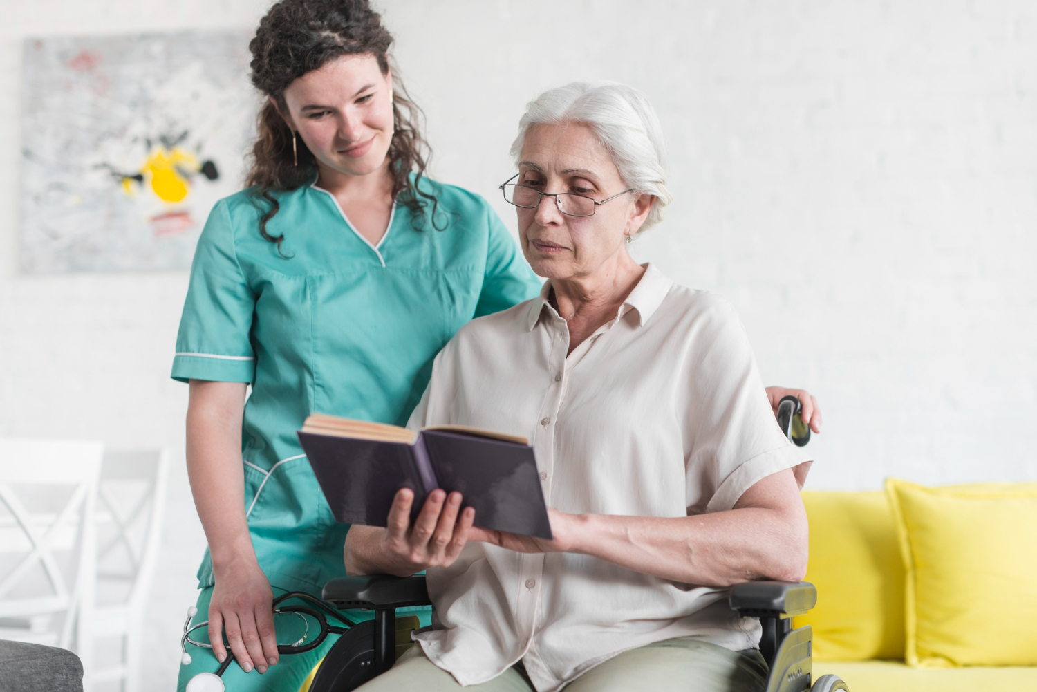 senior-woman-sitting-wheelchair-reading-book-with-nurse-standing